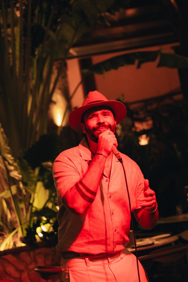 Cantante con sombrero rojo durante una noche de música en vivo en Tito Bravo